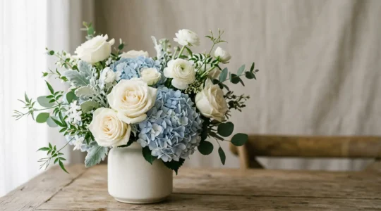 Composition florale élégante de roses et hortensias dans des tons blancs et bleus sur fond épuré